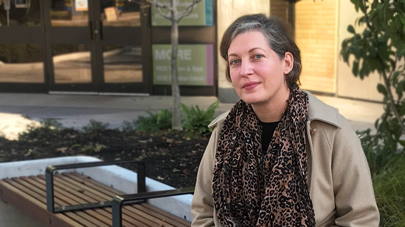 Andrea wearing a scarf sitting on benches in front of VCC downtown campus