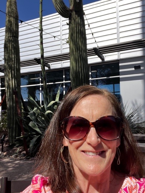 woman in sunglasses smiles for the camera 